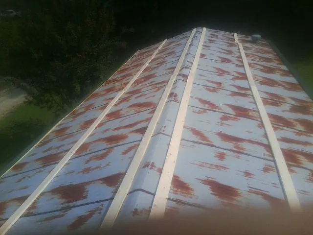 Rusted metal roof panels with new wood purlins before replacement — Storm Damage Roof Repair in Cave Junction by Roofing Brothers