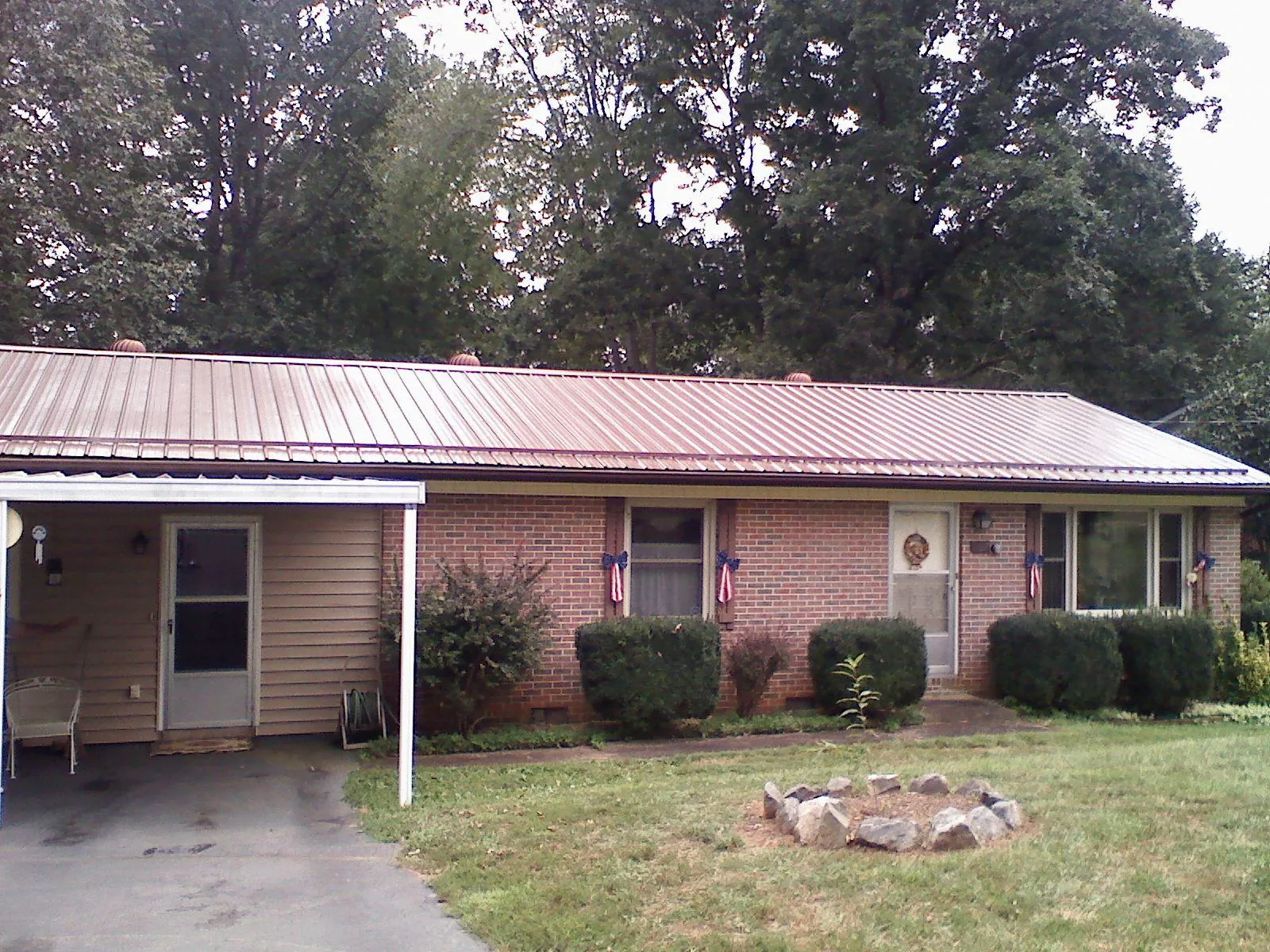 Bronze metal roof and carport on a brick ranch home — Roof Repair work by our crew in Cave Junction